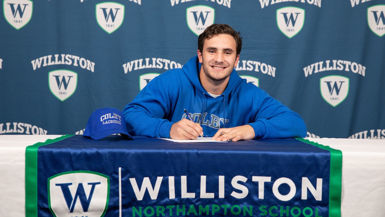 male student sitting at table with Williston northampton school insignia