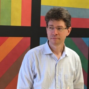 Geoff Hudson man in white shirt standing in front of Sol Lewit artwork