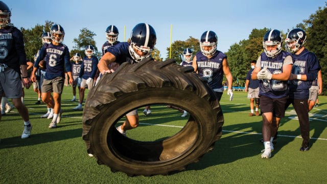 football players tackling tractor tire