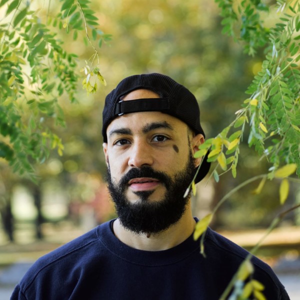 man wearing backwards baseball cap standing outside