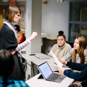 woman standing before young people in classroom