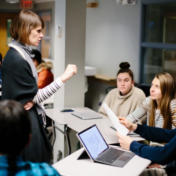 woman standing before young people in classroom