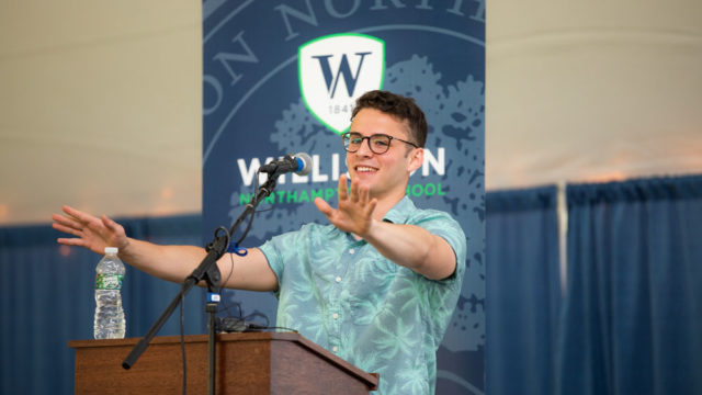 man at podium gestures