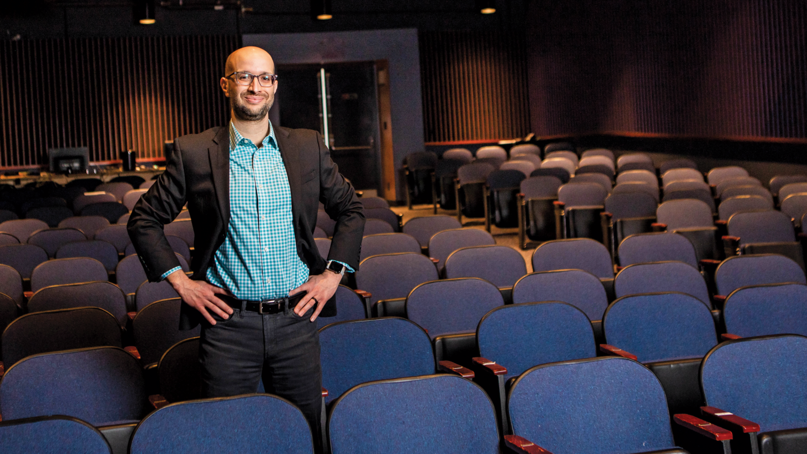 man standing in row of seats in theater