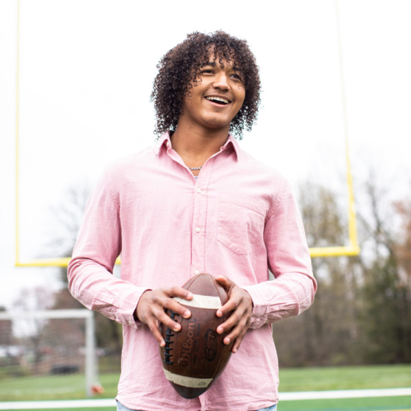 young man with football on field