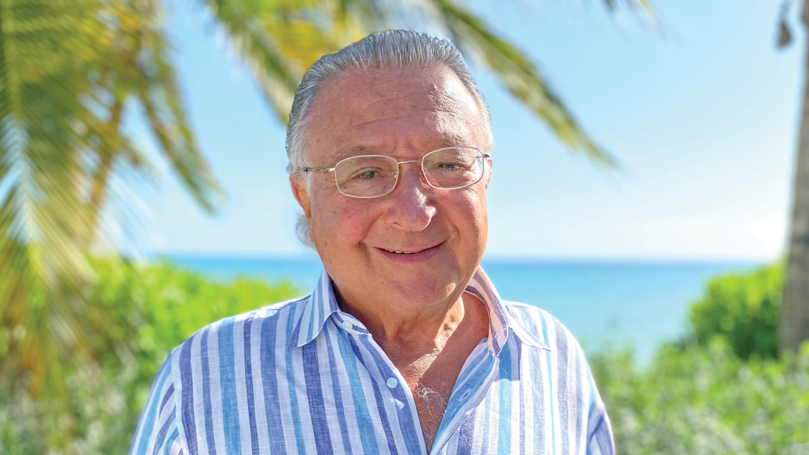 man standing in sun with ocean in background