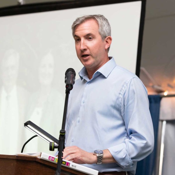 man at podium speaks at mic