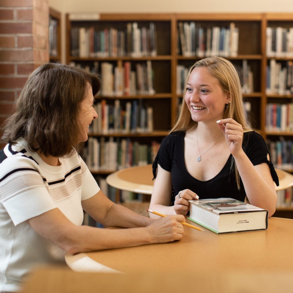 student and teacher in library