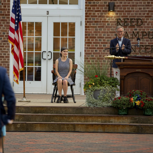 Teacher in chair being applauded