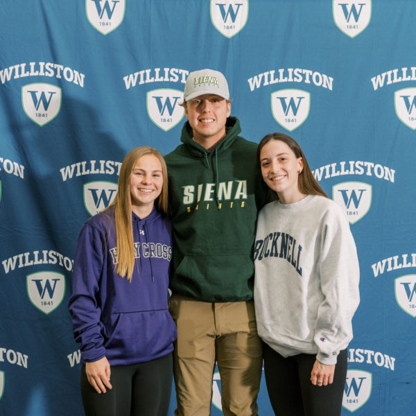 three students in front of banner
