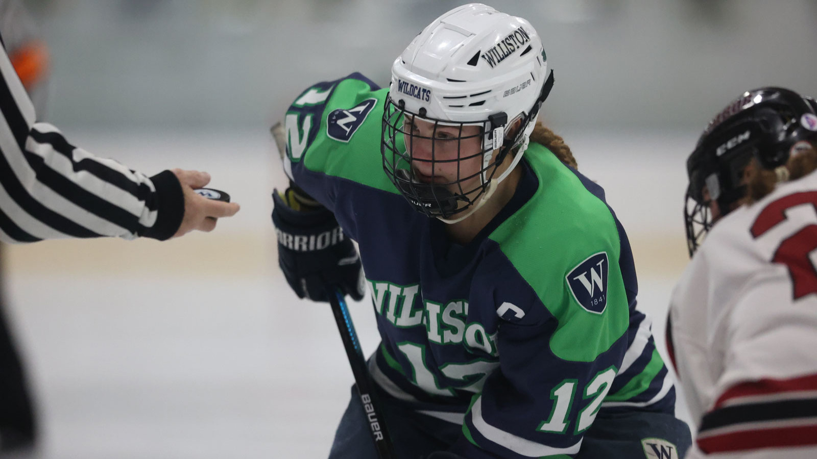 girl playing hockey in uniform and helmet