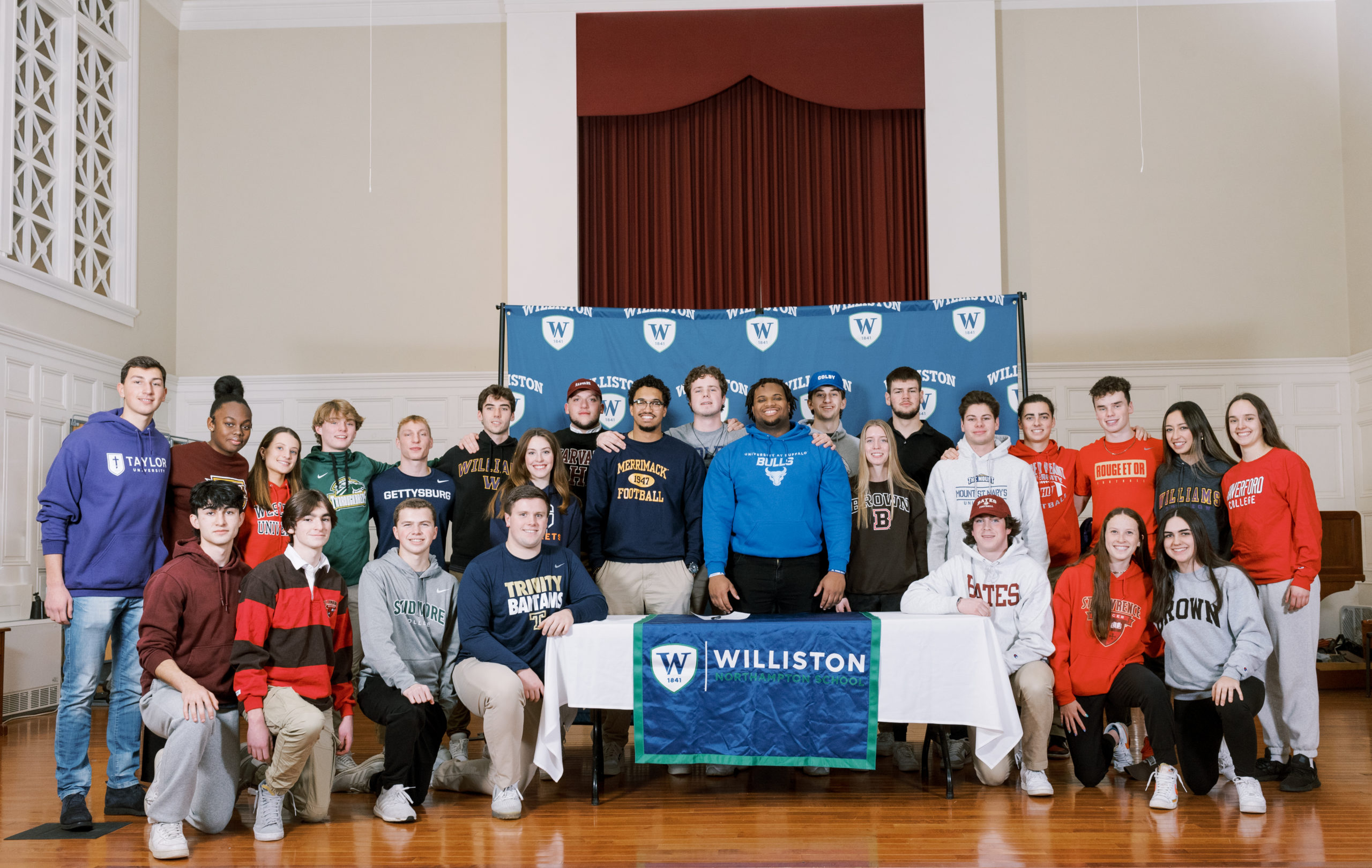 boys, girls williston students stand in chapel for athletic signing ceremony