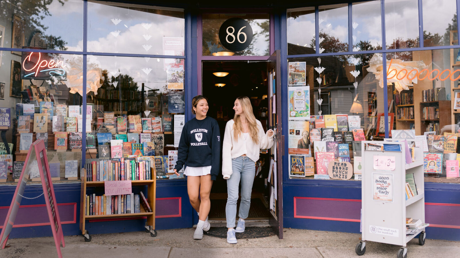 two female students walking through the door of a bookstore