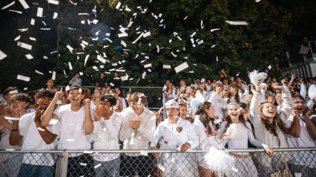 student celebrating at sporting event at night