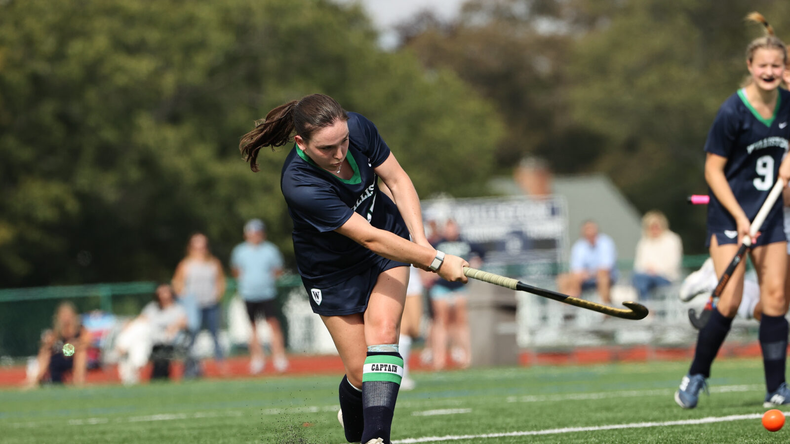 girl playing field hockey