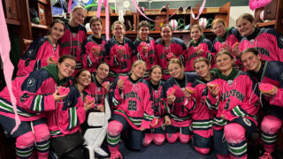 Williston girls hockey players pose for team picture during Pink in the Rink game