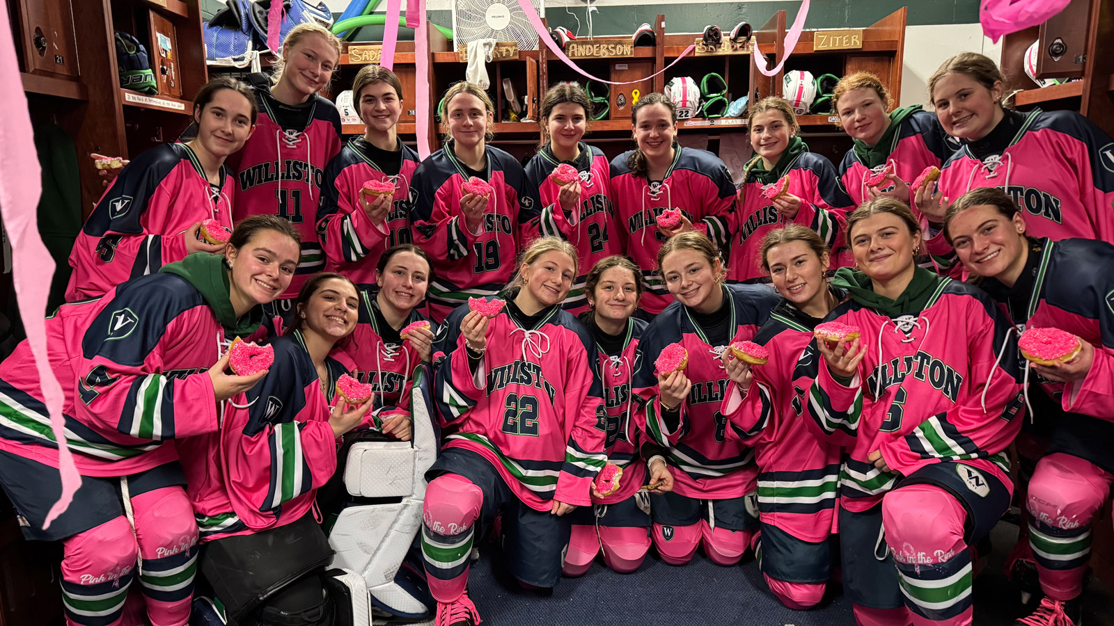 Williston girls hockey players pose for team picture during Pink in the Rink game