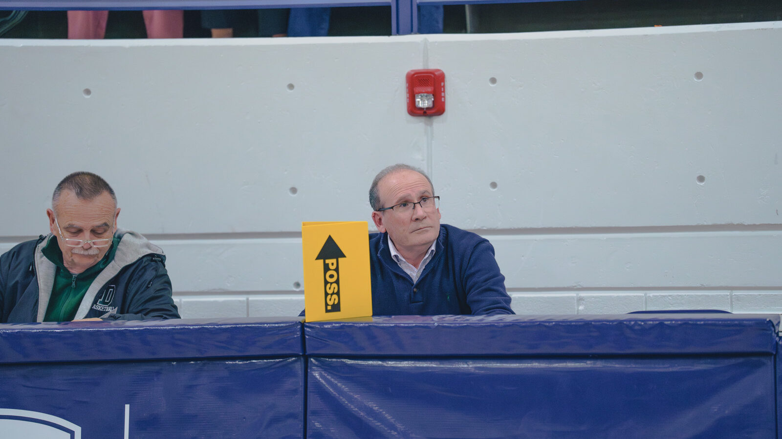 Williston teacher and coach sits at scorers table during basketball game