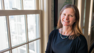 woman in black by window