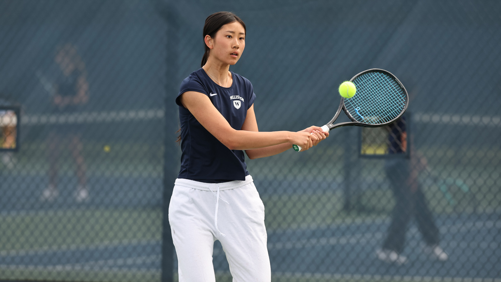 A Williston female tennis player hits a ball during a match