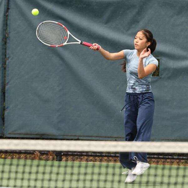 A Williston female tennis player hits a ball during a match