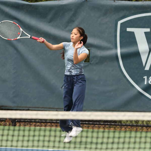 A Williston female tennis player hits a ball during a match