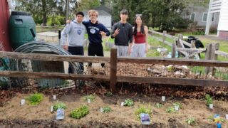 Four Williston students pose for picture in the Community Garden
