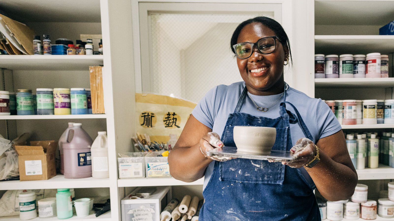 Female student showing a piece of ceramic art