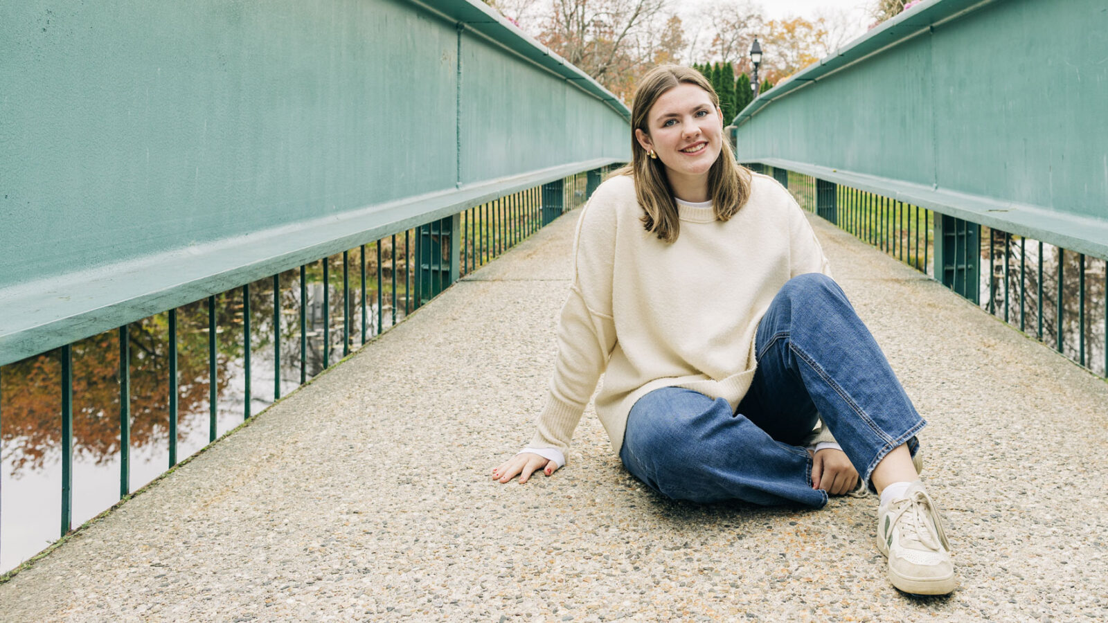 Female student sitting on bridge