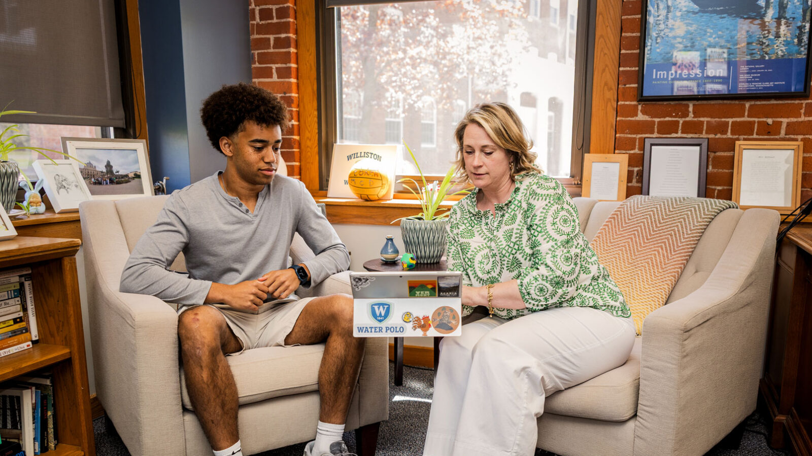 student and college advisor looking at a computer