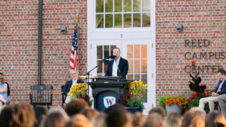 Man speaks at microphone
