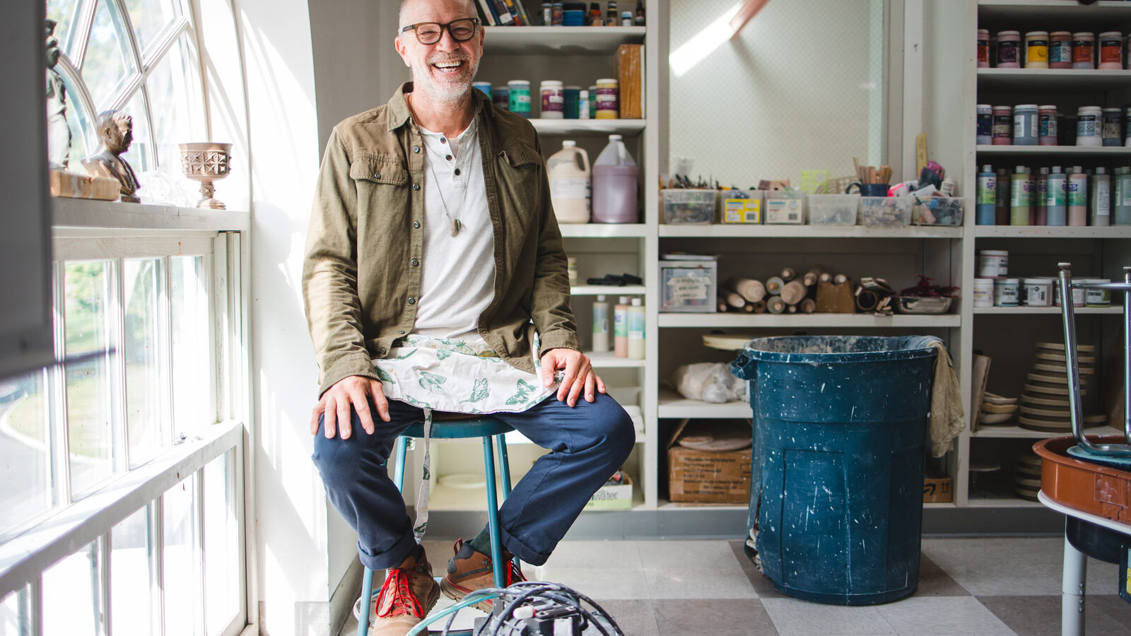 Man sits on stool in art studio